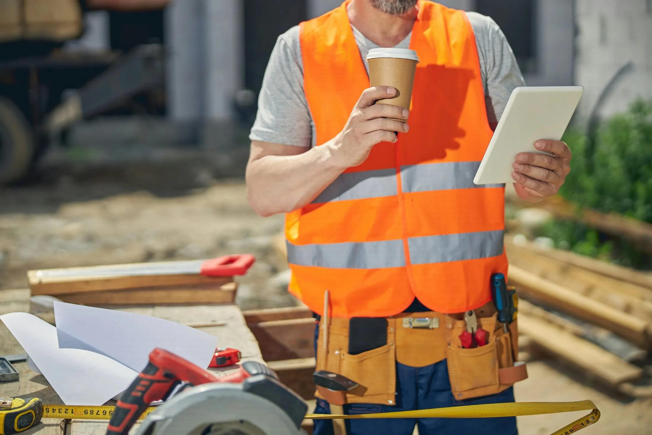 Tradesperson in safety gear holding tools ready for a service call